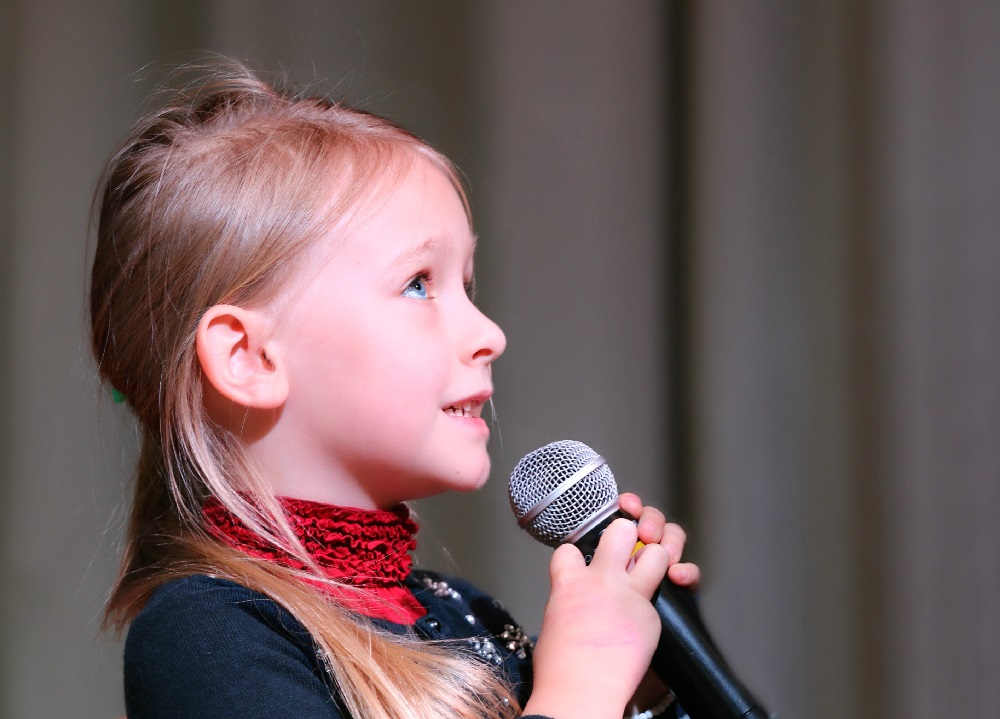 Little girl singing. Representing singing lessons at SFE music school